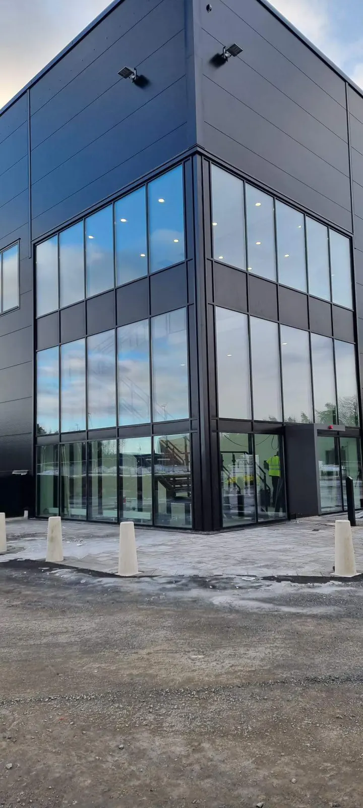 Glasmästarns arbete med en glasfasad i svart aluminium